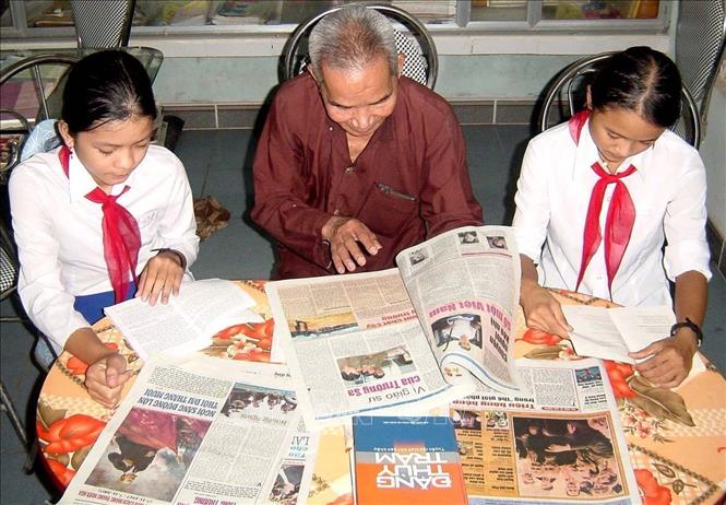 CCB Nguyễn Đức Vũ, 85 tuổi đời, 61 năm tuổi Đảng, ở thôn Nhan Biều 3, xã Triệu Thượng, huyện Triệu Phong (Quảng Trị) để dành lương hưu của mình để xây dựng một ngôi nhà rộng gần 20 m2 làm nơi thờ cúng Bác Hồ. Ngôi nhà khá khang trang, có điện thờ, tủ đựng tài liệu, và đặc biệt là nhiều sách báo, tài liệu, tranh ảnh viết về Đảng, Bác Hồ, đất nước, quê hương do bác Vũ đặt mua hoặc sưu tầm rồi chép thành sách để phục vụ nhân dân trong thôn đến tìm hiểu, nghiên cứu, học tập. Nhân dân địa phương gọi bác với cái tên trìu mến và kính phục “Người truyền lửa tư tưởng, đạo đức Hồ Chí Minh”. Ảnh: Hồ Cầu - TTXVN