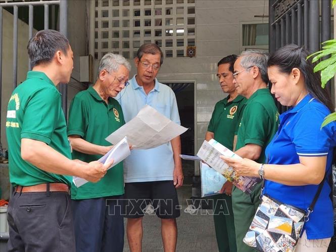 Những người lính cụ Hồ của tổ dân phố 2, phường Thuận Lộc (Thừa Thiên - Huế) tuyên truyền các hộ dân giảm sử dụng đồ dùng bằng nhựa và hướng dẫn phân loại rác tại nguồn. Ảnh: Mai Trang - TTXVN