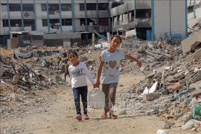 Các em nhỏ đi lấy nước tại Khan Younis, Dải Gaza. Ảnh: THX/TTXVN