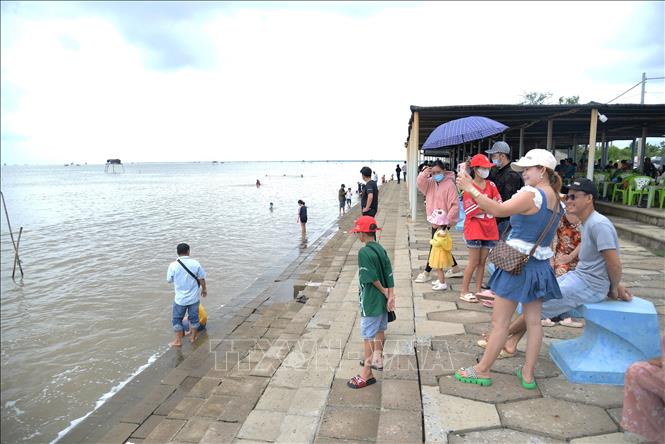Du khách vui chơi tại bãi biển Gò Công. Ảnh: Hữu Chí - TTXVN