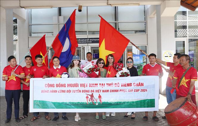 Các cổ động viên Việt Nam tại Lào và cộng đồng người Việt Nam tại Lào chờ đón đội tuyển bóng đá quốc gia Việt Nam trong sảnh đến tại sân bay quốc tế Wattay. Ảnh: Xuân Tú - PV TTXVN tại Lào