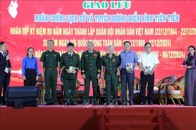 Các nhân chứng lịch sử trao tặng sách lưu niệm cho Ban tổ chức. Ảnh: Trung Kiên - TTXVN