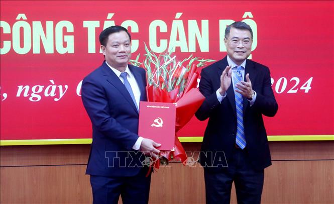 Đồng chí Lê Minh Hưng, Ủy viên Bộ Chính trị, Bí thư Trung ương Đảng, Trưởng Ban Tổ chức Trung ương trao Quyết định, tặng hoa chúc mừng đồng chí Nguyễn Khắc Thận. Ảnh: Thế Duyệt – TTXVN