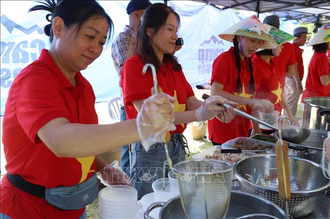 Trong trang phục áo cờ đỏ sao vàng nổi bật và nón lá đầy màu sắc, các cán bộ, nhân viên, các phu quân và phu nhân của Đại sứ quán và các cơ quan đại diện Việt Nam tại Nam Phi cùng tự hào phục vụ thực khách món phở bò và phở gà truyền thống của Việt Nam. Ảnh: Hồng Minh - P/V TTXVN tại Pretoria, Nam Phi