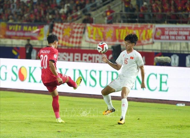 Pha tranh bóng của tiền đạo Bùi Vĩ Hào với cầu thủ đối phương. Ảnh: Đỗ Bá Thành - PV TTXVN tại Lào