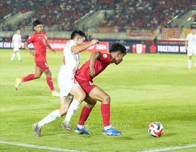 Tiền vệ Nguyễn Hai Long (24) gặp phải sự cản phá quyết liệt của hậu vệ chủ nhà Lào. Ảnh: Đỗ Bá Thành - PV TTXVN tại Lào