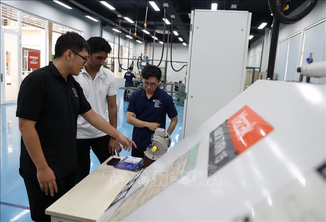 Chuyên viên nghiên cứu Đại học Quốc tế Miền Đông (EIU) trao đổi về công nghệ số. Ảnh: Hồng Đạt - TTXVN
