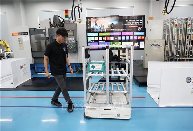 Chuyên viên Nguyễn Quang Giáp giới thiệu phương thức vận hành của xe tự hành AGV. Ảnh: Hồng Đạt - TTXVN
