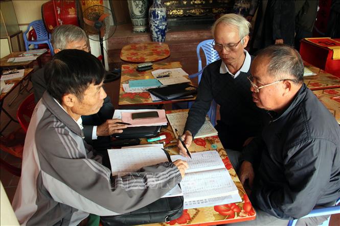 Học viên Câu lạc bộ Hán Nôm Quần Anh (Hải Hậu, Nam Định) trao đổi về chữ Hán, Nôm. Ảnh: Nguyễn Lành - TTXVN