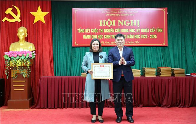 Giám đốc Sở Giáo dục và Đào tạo Hà Nam trao Giấy khen cho lãnh đạo Trường Chuyên Biên Hòa vì đã tổ chức tốt cuộc thi. Ảnh: Đại Nghĩa - TTXVN