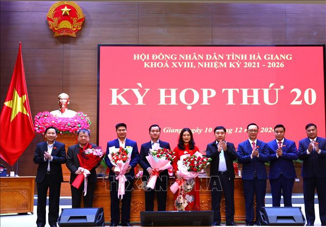 Lãnh đạo tỉnh tặng hoa chúc mừng bà Vương Ngọc Hà được bầu giữ chức Phó Chủ tịch UBND tỉnh Hà Giang và các đồng chí miễn nhiệm chức danh Ủy viên UBND tỉnh khóa XVIII, nhiệm kỳ 2021-2026. Ảnh: Minh Tâm-TTXVN