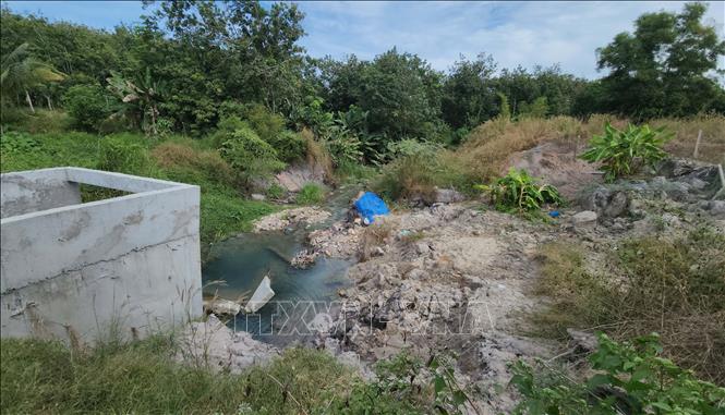 Suối Bưng Hổ sạt lở ảnh hưởng đến nhà cửa, vườn tược của người dân. Ảnh: Đậu Tất Thành – TTXVN