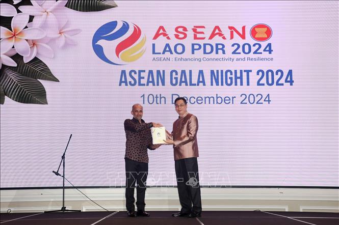 Đại sứ Lào tại Singapore Sengkeo Pouangpadith bàn giao chức chủ trì ASEAN Gala Night cho Cao ủy Malaysia tại Singapore  Azfar bin Mohamad Mustafar. Ảnh: Lê Dương - P/v TTXVN tại Singapore