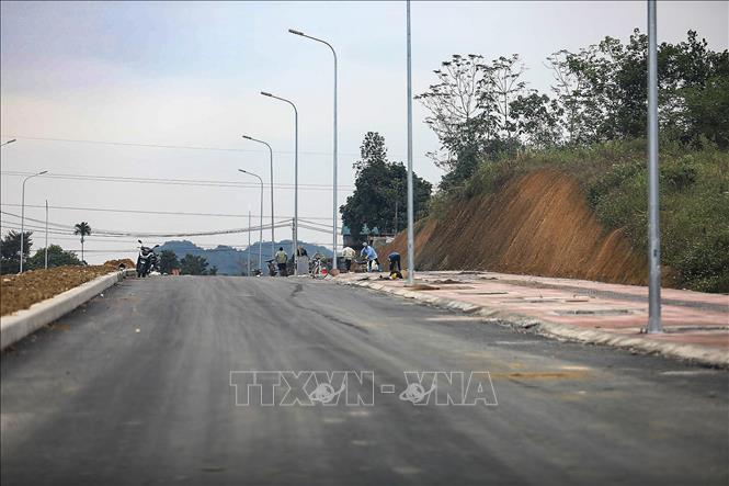 Hiện tại trên tuyến đã thực hiện hoàn thiện các hạng mục cầu qua sông Bùi, hạ tầng kỹ thuật, nền và thảm mặt đường bê tông nhựa, hệ thống rãnh dọc, hào kỹ thuật, hoàn thiện các cống ngang qua đường, lắp đặt các hệ thống đèn chiếu sáng và đang triển khai trồng cây xanh tạo cảnh quan... Ảnh: Trọng Đạt-TTXVN