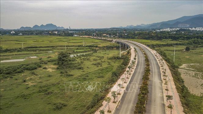 Hiện tại trên tuyến đã thực hiện hoàn thiện các hạng mục cầu qua sông Bùi, hạ tầng kỹ thuật, nền và thảm mặt đường bê tông nhựa, hệ thống rãnh dọc, hào kỹ thuật, hoàn thiện các cống ngang qua đường, lắp đặt các hệ thống đèn chiếu sáng và đang triển khai trồng cây xanh tạo cảnh quan... Ảnh: Trọng Đạt-TTXVN