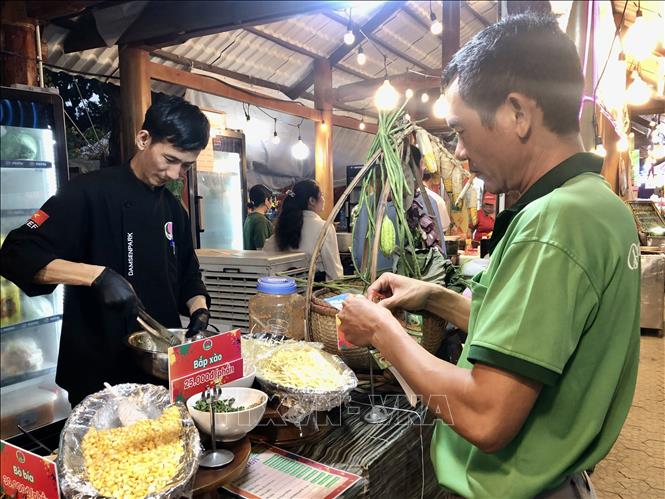 Thực khách sử dụng coupon để gọi món ăn. Ảnh: Mỹ Phương – TTXVN.