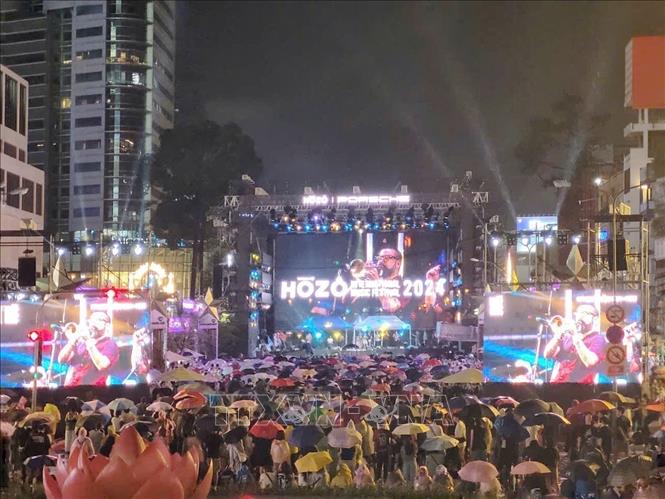 The audiance enjoys the performance in the rain. VNA Photo: Thu Hương