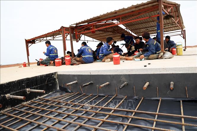 Với tinh thần “ăn tranh thủ, ngủ khẩn trương”, những công nhân ăn trưa ngay trên công trường thi công đường băng của siêu dự án sân bay quốc tế Long Thành. Ảnh: Hồng Đạt - TTXVN
