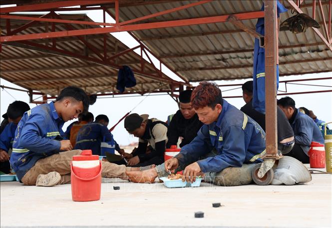 Công nhân nghỉ ngơi, ăn cơm trưa ngay trên công trường thi công đường băng sân bay quốc tế Long Thành. Ảnh: Hồng Đạt - TTXVN
