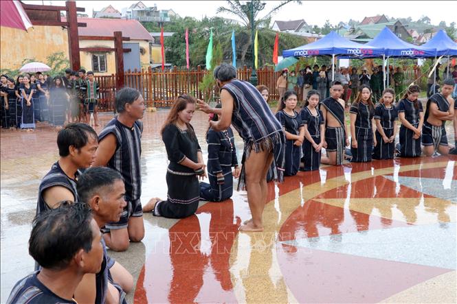 Già làng bôi tiết gà hiến tế lên mặt để cầu phúc cho dân làng. Ảnh: Chu Quốc Hùng - TTXVN