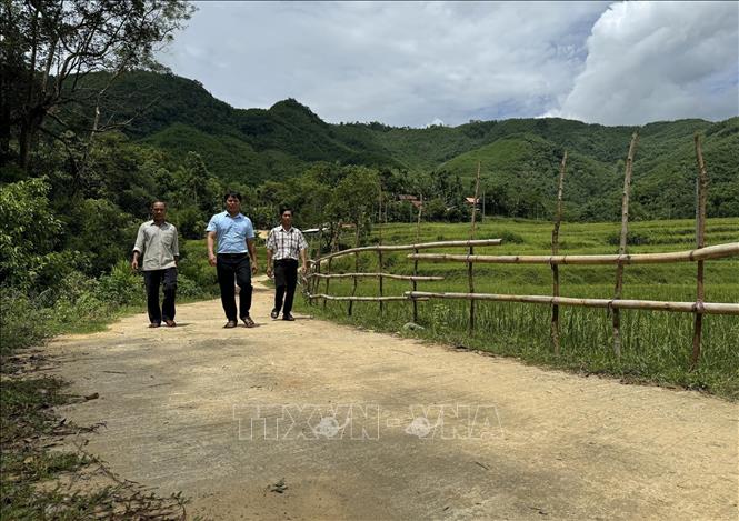 Đường tới thôn Gò Khôn được mở rộng nhờ ông Phạm Văn Nó (trái) vận đồng người dân cùng hiến đất làm đường. Ảnh: Đinh Hương - TTXVN