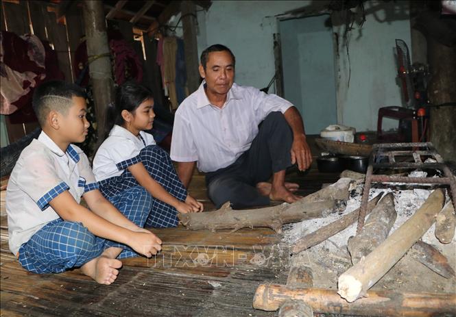 Ông Đinh Văn Na, người có uy tín tại thôn Làng Ranh, xã Sơn Ba, huyện Sơn Hà thường xuyên thăm hỏi, động viên các cháu nhỏ gia đình có hoàn cảnh khó khăn, cha mẹ đi làm ăn xa. Ảnh: Đinh Hương-TTXVN