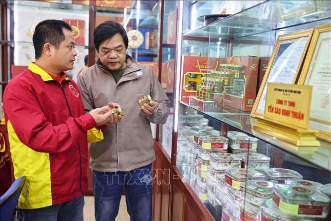 Anh Đinh Văn Thuận giới thiệu các sản phẩm được chế biến từ tổ yến với khách hàng. Ảnh: Minh Đức - TTXVN