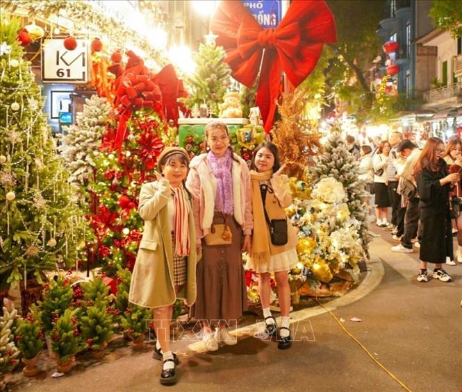 Friends and families enjoy Christmas decorations around Hanoi. VNA Photo: Khánh Hoà