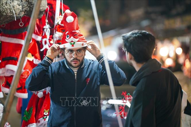 A visitor buying Christmas decorations and items on Hang Ma street. VNA Photo: Khánh Hoà