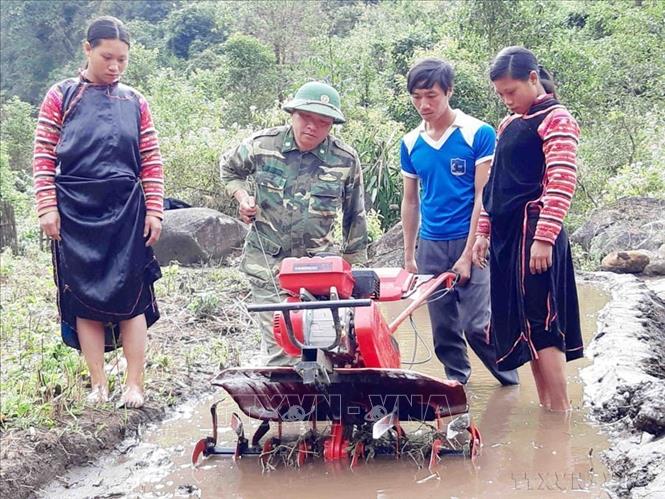 Cán bộ, chiến sỹ Bộ đội Biên phòng Lai Châu hướng dẫn bà con sử dụng máy cày làm đất để trồng lúa nước, mang lại hiệu quả kinh tế cao. Ảnh: Công Tuyên-TTXVN