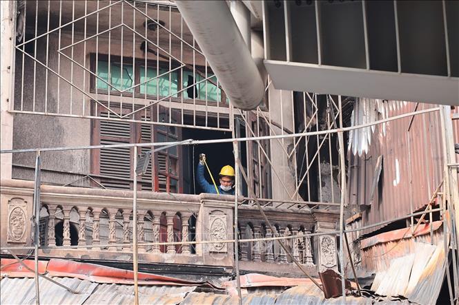 Ccơ quan điều tra hiện trường vụ cháy. Ảnh: Hoàng Hiếu - TTXVN
