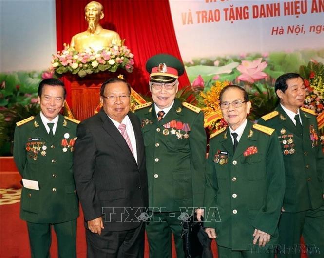 Tổng Bí thư, Chủ tịch nước CHDCND Lào Bounnhang Vorachith cùng các cựu chiến binh Việt Nam tại Lễ kỷ niệm 70 năm Ngày truyền thống Quân tình nguyện và Chuyên gia Việt Nam tại Lào (2019). Ảnh: Trọng Đức - TTXVN