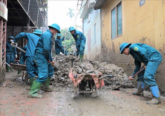 Lực lượng dân quân tự vệ tham gia khắc phục, thu dọn vệ sinh sau khi nước rút tại thành phố Yên Bái. Ảnh: Tuấn Anh – TTXVN