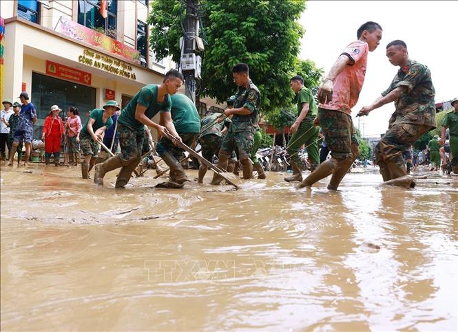 Bộ đội giúp nhân dân thành phố Yên Bái dọn dẹp bùn đất sau lũ quét. Ảnh: Dương Giang - TTXVN