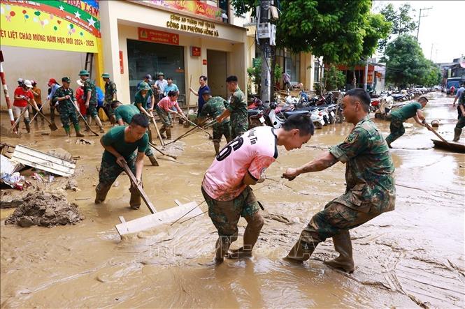 Bộ đội giúp nhân dân thành phố Yên Bái dọn dẹp bùn đất sau lũ quét. Ảnh: Dương Giang - TTXVN