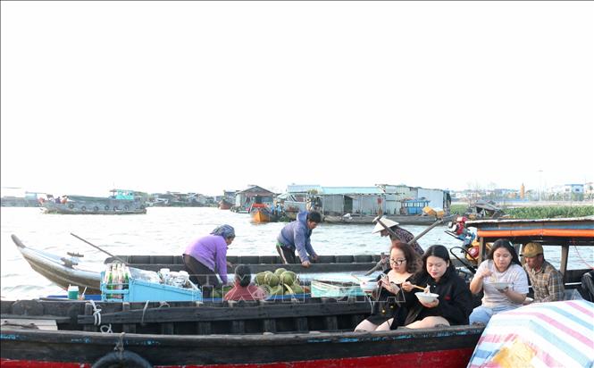 Trải nghiệm ăn trên những chiếc ghe bồng bềnh giữa mênh mang sóng nước ở chợ nổi Long Xuyên là điều khá thú vị, khác lạ. Ảnh: Công Mạo-TTXVN