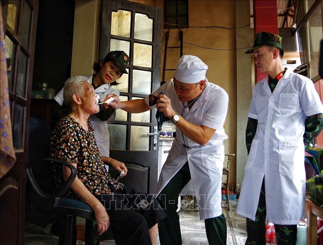 Bác sĩ quân y Sư đoàn 325 khám, chữa bệnh cho nhân dân trong vùng lũ huyện Lục Ngạn (Bắc Giang). Ảnh: Danh Lam - TTXVN