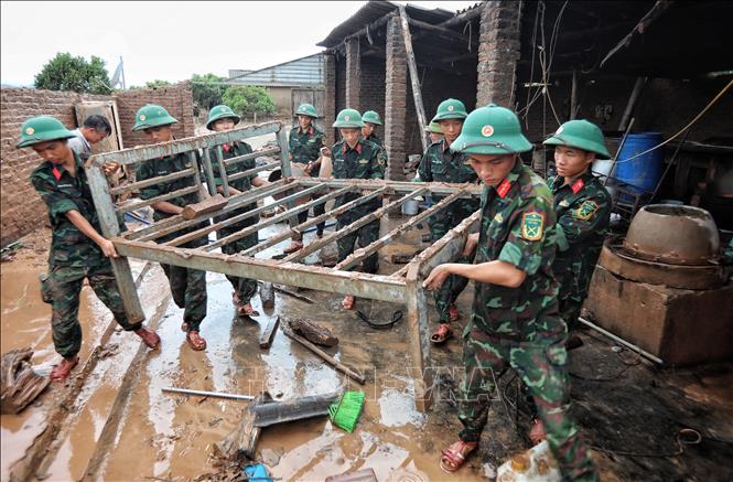 Cán bộ, chiến sĩ Sư đoàn 325 hỗ trợ gia đình anh Nguyễn Văn Hồng, thôn Thủ Dương, xã Nam Dương, huyện Lục Ngạn (Bắc Giang) bị sập nhà do lũ. Ảnh: Danh Lam - TTXVN 