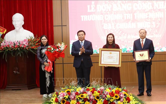Đồng chí Nguyễn Xuân Thắng trao Bằng công nhận và tặng biểu trưng Trường Chính trị tỉnh Ninh Bình đạt chuẩn mức 1 cho Ban Giám hiệu nhà trường. Ảnh: Hải Yến - TTXVN