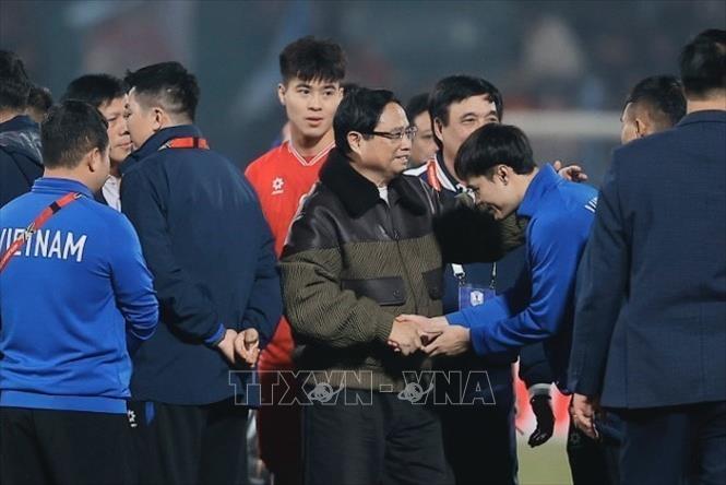 Thủ tướng Phạm Minh Chính xuống sân chia vui với đội tuyển quốc gia Việt Nam. Ảnh: Minh Quyết - TTXVN