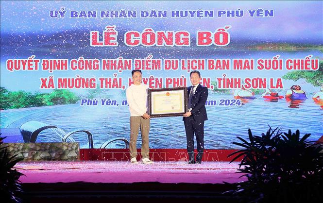 Chủ tịch UBND tỉnh Sơn La Nguyễn Đình Việt trao Quyết định công nhận điểm du lịch Ban Mai Suối Chiếu. Ảnh: Quang Quyết -TTXVN  