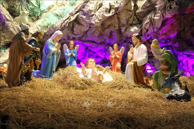 Hang đá Bethlehem nơi đặt tượng Chúa Jesus hài đồng, hai bên máng cỏ là bò, lừa, Đức Mẹ Maria và Thánh Joseph được trang trí tỉ mỉ, bắt mắt. Ảnh: Văn Tý-TTXVN