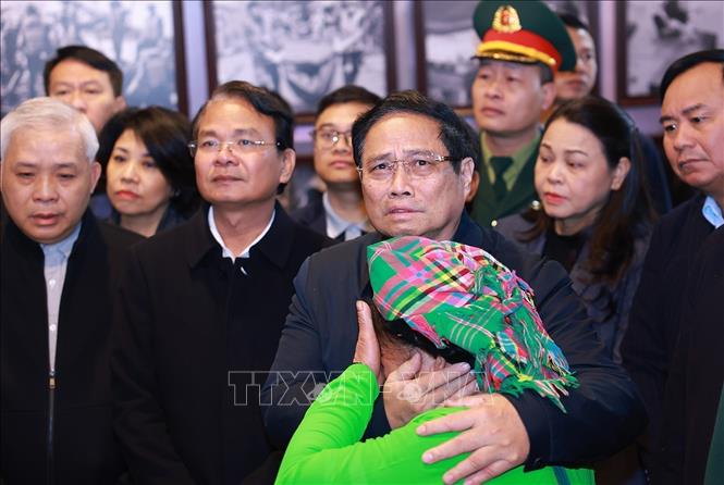 Prime Minister Pham Minh Chinh gives encouragement to a Nu villager whose relatives passed away during the historical flash flood in September. VNA Photo: Dương Giang