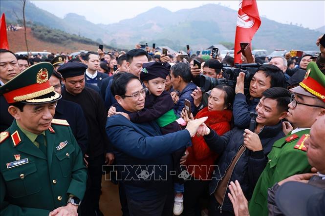 Prime Minister Pham Minh Chinh meets local people living at the Nu village's reconstruction project in Bao Yen district, Lào Cai Province. VNA Photo: Dương Giang