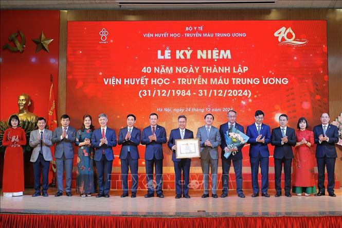 Thứ trưởng Bộ Y tế Trần Văn Thuấn trao Bằng khen của Bộ trưởng Bộ Y tế tặng Viện Huyết học - Truyền máu Trung ương. Ảnh: Minh Quyết - TTXVN