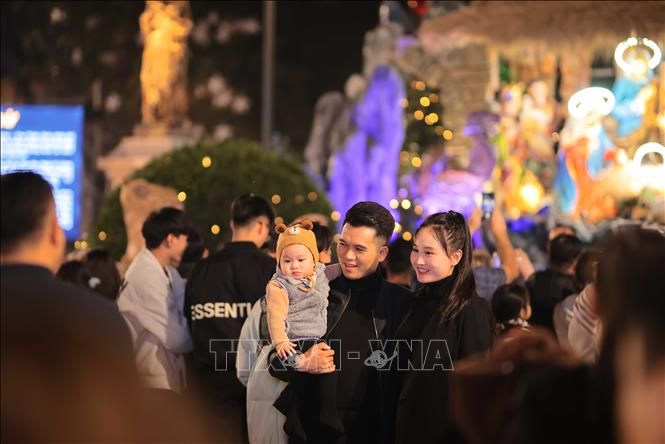 A family captures the memory of Christmas at Saint Joseph's Cathedral in Hanoi. VNA Photo