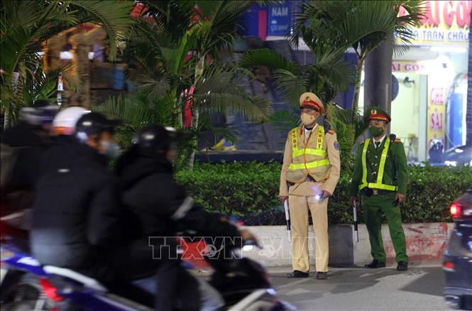 Cán bộ, chiến sĩ tổ công tác Y18A 141H Công an quận Hà Đông làm nhiệm vụ tại tuyến đường Quang Trung, quận Hà Đông. Ảnh: Phạm Kiên - TTXVN