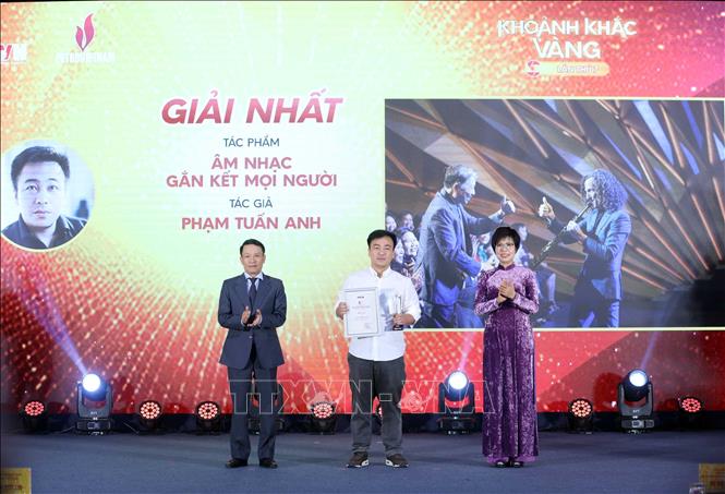 Tổng Giám đốc TTXVN Vũ Việt Trang và Phó Chủ tịch thường trực Hội Nhà báo Việt Nam Nguyễn Đức Lợi trao giải Nhất cho tác giả Phạm Tuấn Anh (Hà Nội) với tác phẩm ảnh đơn 