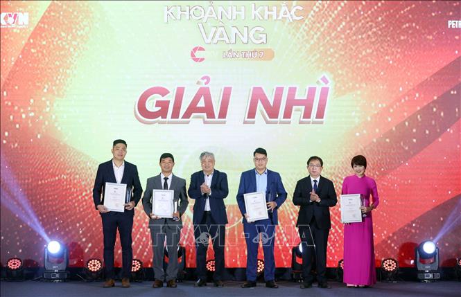 Phó Tổng Giám đốc TTXVN Nguyễn Tuấn Hùng và nguyên Tổng Giám đốc TTXVN Trần Mai Hưởng trao giải Nhì cho các tác giả đạt giải. Ảnh: Phạm Kiên - TTXVN