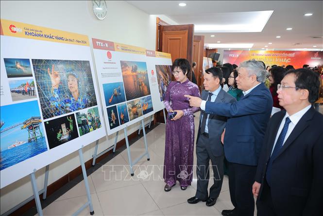 Tổng giám đốc TTXVN Vũ Việt Trang cùng các đại biểu tham quan trưng bày 22 tác phẩm xuất sắc đạt Giải ảnh báo chí Khoảnh khắc Vàng lần thứ 7. Ảnh: Hoàng Hiếu - TTXVN